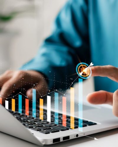Businessman analyzing company's financial balance sheet working with digital augmented reality graphics. Businessman calculates financial data for long-term investment.